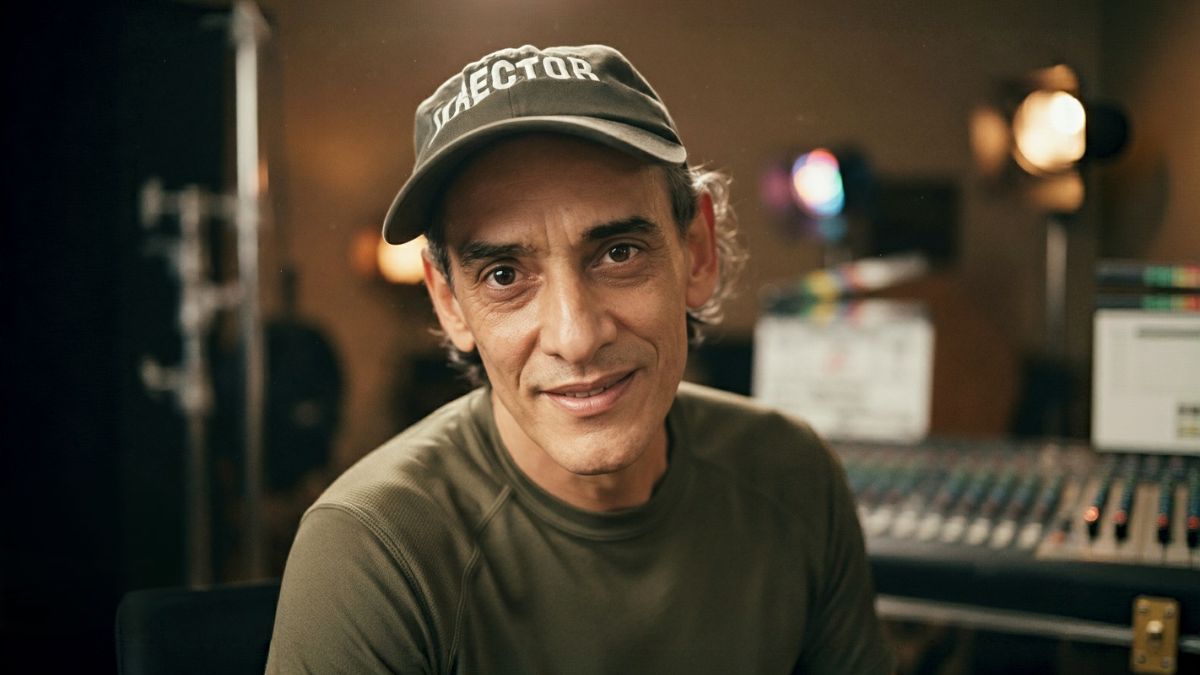 Retrato de Manolito Rodríguez, director de cine, sonriendo en su estudio de postproducción con consola de mezcla y monitor al fondo